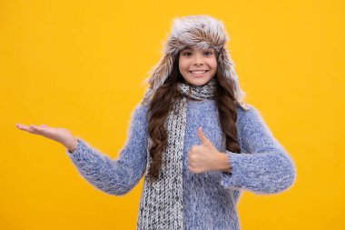 Winter hat. Cold season concept. Winter fashion accessory for children. Teen girl wearing warm knitted hat. Happy face, positive and smiling emotions of teenager girl