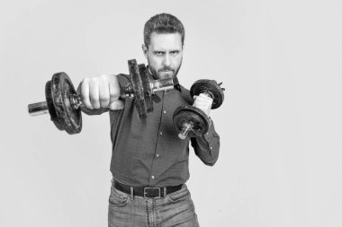 Başarılı, olgun, sakal eğitimi almış bir iş adamı halterle, kopyalama alanıyla, güçle yumruk atıyor..