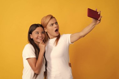 Görüntülü arama yapıyorum. Anne-kız vloglama. Online iletişim. Anne ve çocuk blogu. Dost canlısı kadın ve kız cep telefonunda selfie için poz veriyor. Selfie ailesi. Modern hayat. mobil teknoloji.