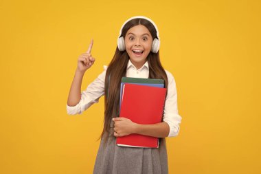 Kopya kitabı olan liseli kız izole edilmiş arka planda poz veriyor. Edebiyat dersi, ilkokul. Entelektüel çocuk okuyucusu. Heyecanlı bir yüz, neşeli genç bir kız.