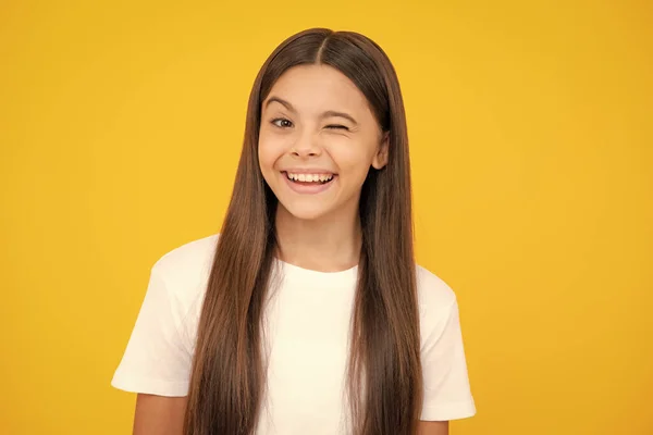 stock image Funny face. Teenager child girl close one eye, winks and smiling. Human facial emotions concept. Funny winking face gesture