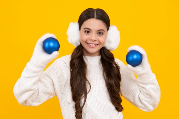 Merry christmas and happy New year. Kid in winter clothes. Teen girl with decorative christmas ball. Happy face, positive and smiling emotions of teenager girl