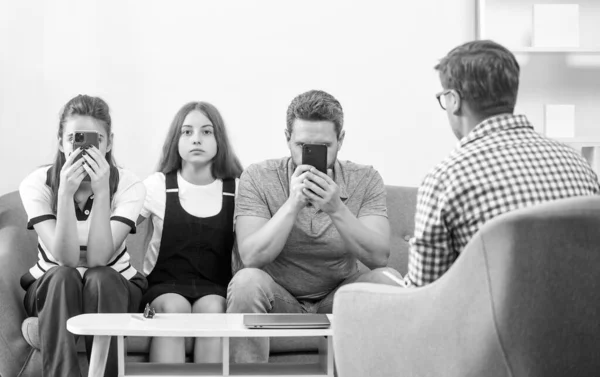 stock image kid with phone addicted daddy and mom sitting at psychologist solving problem, relationship.