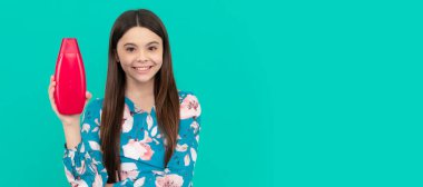 Mutlu kız şampuan şişesini tutuyor. Saç kremi kullanan bir çocuk. Günlük alışkanlıklar ve kişisel bakım. Çocuk saçı bakımı afişi, fotokopi alanı olan poster başlığı