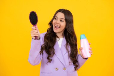 Şampuan kremi kullanan bir çocuk. Günlük kozmetik bakım. 12, 13, 14 yaşlarındaki ergen çocuğun elinde saç ve cilt bakımı şişesi var. Güzellik sağlığı ve kozmetik ürünleri. Mutlu yüz, pozitif ve gülümseyen