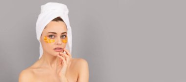 Eye patches, patch under eyes. sensual lady with terry towel use facial golden eye patch for skin, hydrogel. Beautiful woman isolated face portrait, banner with mock up copy space