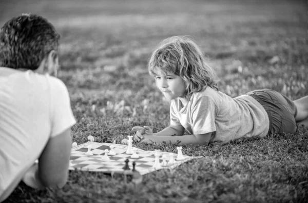 快乐的家庭男人的父母和儿子在公园的绿草上下棋 家庭关系 — 图库照片