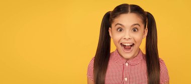 Ne hoş bir sürpriz. Kız şaşkınlıkla ağzını açık tutuyor. Şaşırmış çocuk sarı arka plan. Çocuk yüzü, yatay poster, izole edilmiş genç kız portresi, fotokopi alanı olan pankart