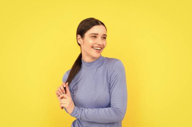 Sarı arka plandaki bayanın portresi. Olumlu duygularını ifade et. Cilt bakımı ve saç bakımı. Neşeli esmer kadın. Güzellik ve moda. Kadın manken. Genç kızın güzel görünüşü..