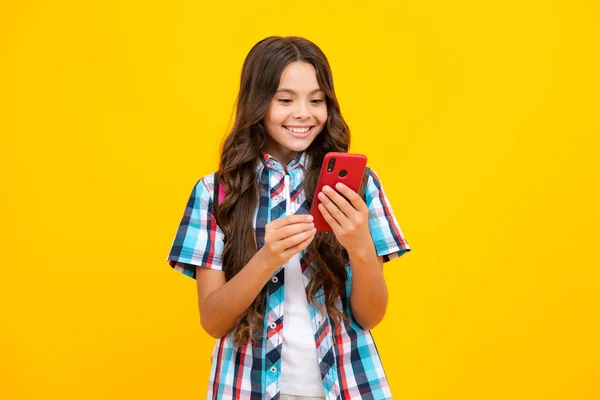 小孩子拿着手机 用手机 手机网络应用拍摄的可爱少女的特写镜头 与明亮生动的黄色背景相隔离 — 图库照片