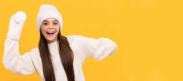 戴着冬帽和手套的孩子很吃惊 带着黄色背景雪球的孩子 圣诞小女孩的横幅 带复制空间的工作室小孩冬季肖像 — 图库照片