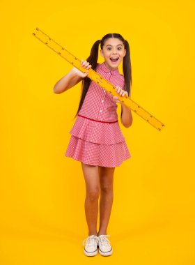 Amazed teenager. Teenager child school girl holding measure for geometry lesson. Measuring height. Measuring equipment. Kid student study math. Knowledge day. Excited teen schoolgirl