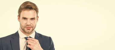 Portrait of serious professional man adjusting necktie in formal business suit. Man face portrait, banner with copy space. Business man in suit, isolated studio background, banner poster