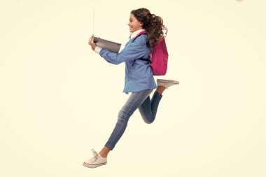 Run and jump, jumping kid. Schoolgirl in school uniform with laptop. Schoolchild, teen student on white isolated background