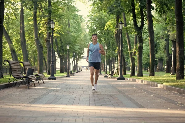 Spor giysileriyle koşan atletik bir adam. uzaklık çalışıyor.