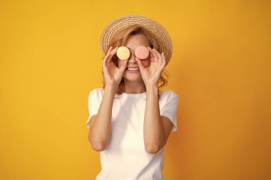 Komik kadın gözünün önünde iki pasta tutuyor. Hippi kız. Sarı arka planda lezzetli badem kurabiyesi yiyen genç bir kadın. Kızım, makaronu ye.