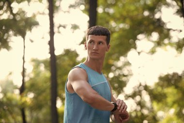 Aktif giyimde koşan bir adam Akıllı Saati kontrol ediyor.