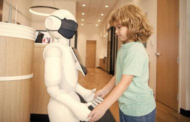 Küçük çocuk robotla yenilikçi teknoloji ve iletişim gibi etkileşim içinde..