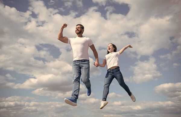 happy father and daughter jump in sky. freedom.