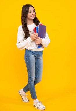 Genç kız öğrenci kitapları, not defterleri, sarı arka planda izole edilmiş, kopyalama alanı. Okula dönüş, gençlik yaşam tarzı, eğitim ve bilgi. Mutlu yüz, pozitif ve gülümseyen duygular.