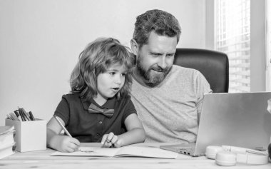 Olgun erkek öğretmen ya da baba oğluna bilgisayar ödevinde yardım ediyor..