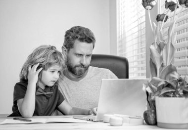 Evde eğitim ve para kazanmak. Okula dönüyorum. Baba ve çocuk evde bilgisayar kullanıyorlar. Aile ve ebeveynlik blogu. Çocuk özel öğretmeniyle ödev yapıyor. Webinar video dersi. dizüstü bilgisayarda online eğitim.