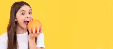 Mutlu çocuk sarı arka planda greyfurt yer, vitamin. Greyfurt portakallı çocuk portresi, yatay poster. Kopyalama alanı olan başlık