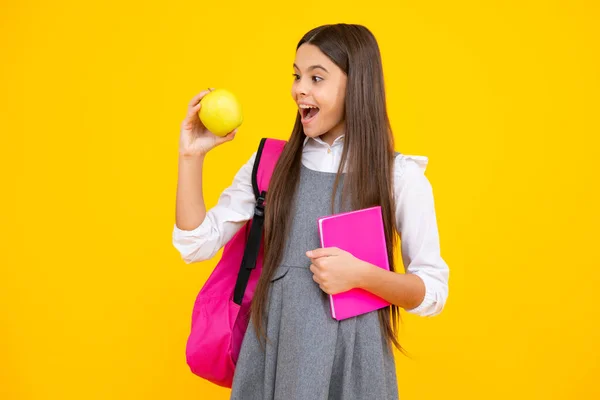 stock image Excited face. School girl hold copybook and book on yellow isolated studio background. School and education concept. Teenager girl in school uniform. Amazed expression, cheerful and glad