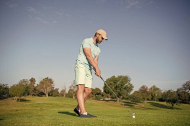 Golf sopası ve golf sahası ile meşgul bir golfçü..