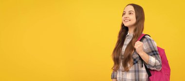 Okula dönüyorum. Bilgi günü. Eğitim konsepti. Sarı arka planda kareli tişörtlü bir çocuk. Öğrenci portresi, stüdyo afişi. Okul çocuğu yüzü, boşluklar