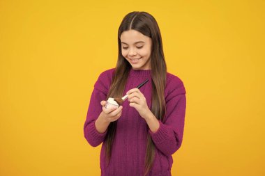 12, 13, 14 yaşlarında pudra ve fırçayla güzellik yapan bir kız çocuğu. Makyaj yapan güzel genç.