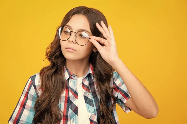 Teenager child with poor eyesight wear eyeglasses, looking squinting. Kids glasses. Funny surprised adorable girl in round glasses having astonished shocked facial expression