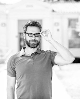 Olgun inek öğretmen zeki görünüyor. Tıraşsız gülümseyen adam gözlüklerinden bakıyor. Görüş keskinliği. Görme. Vizyon düzeltmesi. Göz sağlığı. Optik göz merceği. Okula dönüyorum. bilgi ve eğitim.