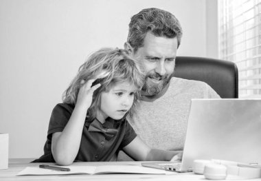 Okulda mutlu baba ve çocuk bilgisayarda ve video konferansında çalışıyor..