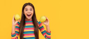 Heyecanlı kız çocuğu sağlıklı diş sarısı arkaplan için elma tutuyor. Elmalı çocuk portresi, yatay poster. Kopyalama alanı olan başlık