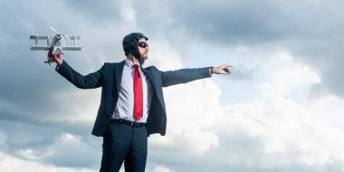 Yetişkin iş adamı takım elbiseli ve pilot şapkalı uçak fırlatma oyuncağı.