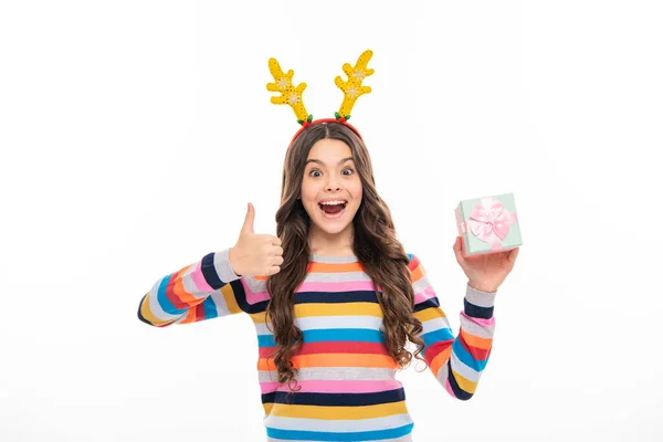 stock image Teen girl wear winter sweater and deer antlers, hold gift celebrating christmas holidays on white studio background. Merry Christmas presents, Happy New Year celebration