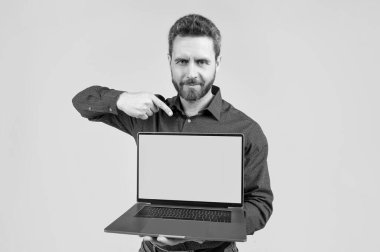 Olgun adam yeşil ekran gösteriyor. Modern kablosuz laptop. kopyalama alanı. Webinar PC reklamı. İş adamı ürünü sunuyor. Bilgisayarda sunum. Ofis müdürü video konferansında parmağıyla işaret etti