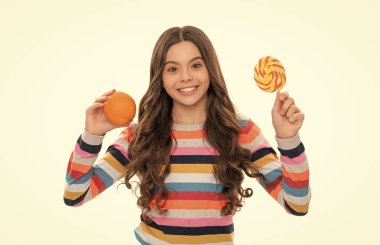 Portakal meyveli renkli kazaklı mutlu çocuk ve beyaz vitaminli lolipop..