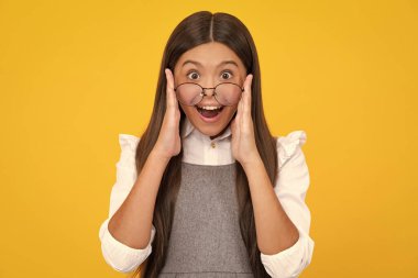 Excited face, cheerful emotions of teenager girl. Portrait of teenager child girl in glasses. Kid at eye sight test. Girl with eyeglasses and looking at camera. Vision for children