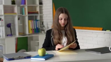 Ödev okuyan öğrenci sınıfta yanlışlıkla kağıt sıkıyor, eğitim görüyor..