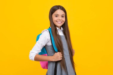 Sırt çantalı kız öğrenci. Tecrit edilmiş genç bir öğrenci. Öğrenme ve bilgi. Git çalış. Çocuk eğitimi konsepti. Okula dönelim. Mutlu kız yüzü, pozitif ve gülümseyen duygular