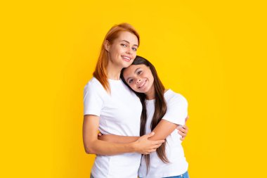 Genç kız ve anne portresi. İnanılmaz güzel iki insan anne ve kızı sarılıyorlar sarı arka planda izole edilmiş güzel sarılıyorlar.