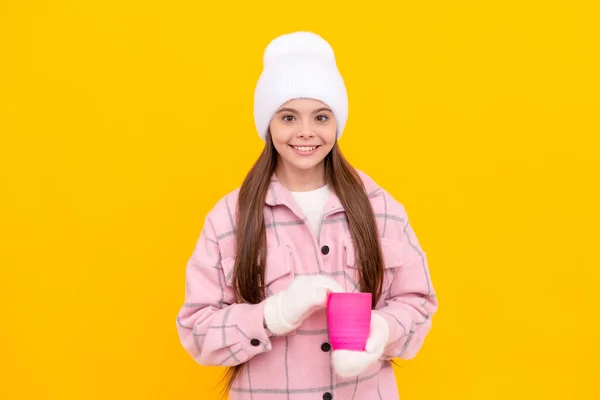 暖かい服を着た幸せな子供 お茶を飲んで 帽子の子供だ 黄色を基調とした女性ファッションモデル コーヒーカップを持つミトンの10代の女の子 — ストック写真