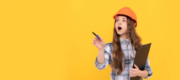 Renovation child, shocked teen girl in helmet and checkered shirt making notes on clipboard, working. Child in hard hat horizontal poster design. Banner header, copy space