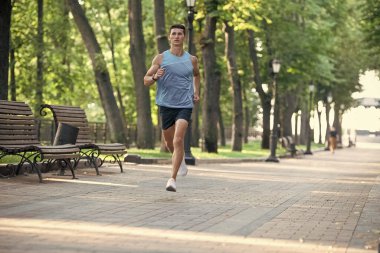 Spor giysileriyle koşan atletik bir adam. Anaerobik yük.