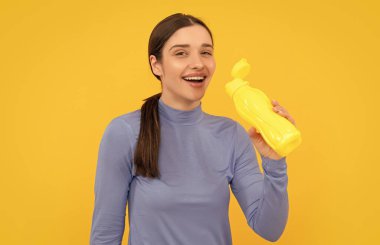 Plastik şişeli genç kız. Sağlıklı bir yaşam tarzı. Vücuttaki su dengesi. Günde bir içki. Sıvı yeterliliği. Susuz kalma. Genç kadın maden suyu tutuyor. Susadım..