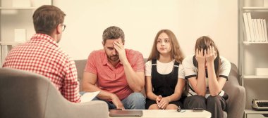 Sosyal görevli psikolog, baba ve kız çocuğuyla konuşuyor. Tavsiye, yardım, destek. Psikoloji terapisi, aile ruhsal sağlığı. Üzgün baba, anne ve çocuk aile psikoloğunda.