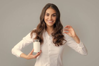 Woman with bottle pills. Happy young African American woman holding bottle of dietary supplements or vitamins in her hands. Healthy lifestyle concept