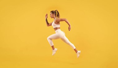 Sarı arka planda çalışan fitness kadın koşucusu.